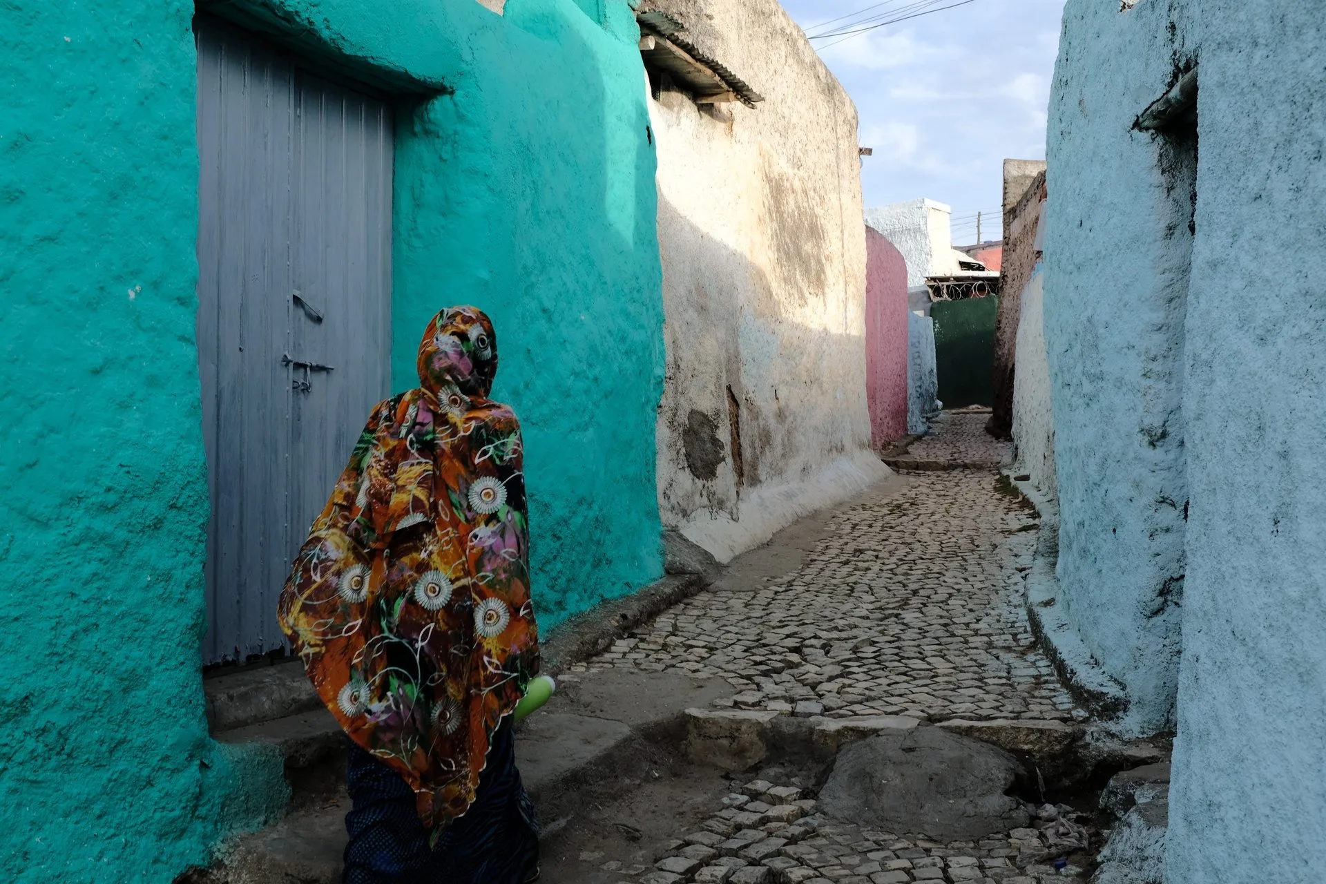 Historic whitewashed stone walls and colorful doorway in an alley of Harar Jugol, Ethiopia